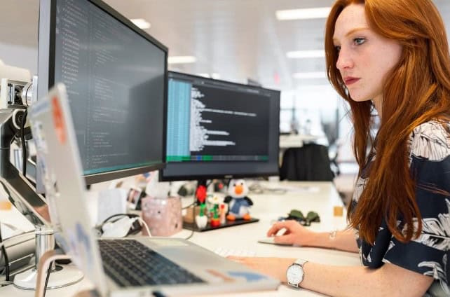 Alt text: A woman in an office researching purchase intent on her computer 