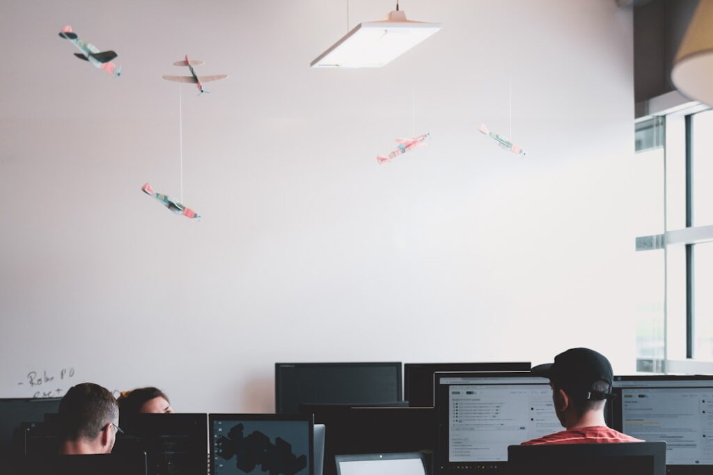 A group of coworkers at their workstations, while one employee looks up what encompasses organizational knowledge.